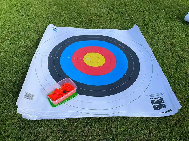 A colourful archery target face laid on the grass.