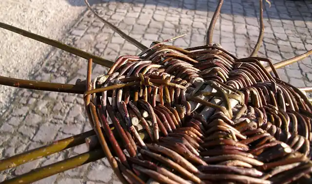 A close view of wicker being woven into a basket.