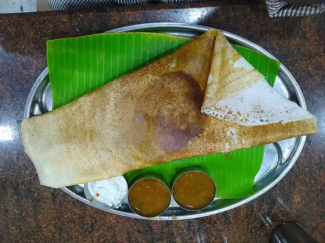 A crisp dosa served with chutneys and sambar.