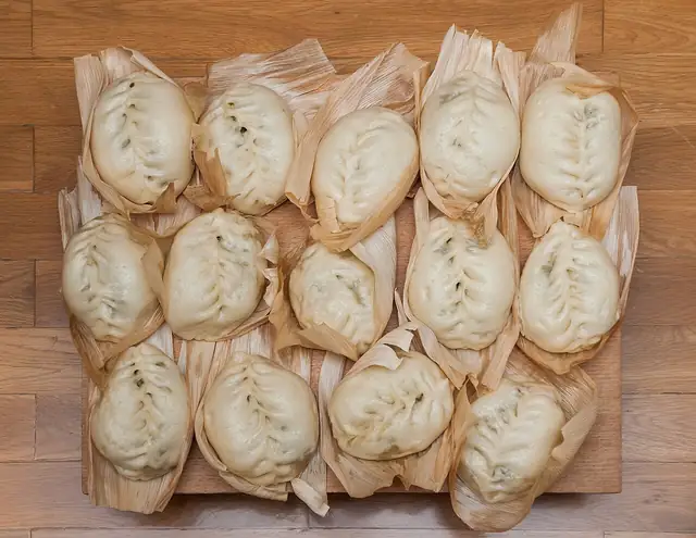 Freshly folded dumplings arranged on a tray.