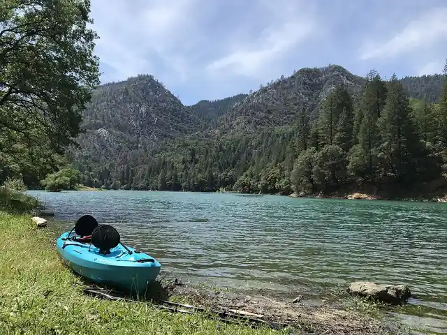 A kayak beside calm water.