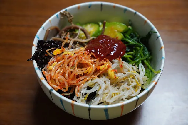 A bowl of Korean bibimbap with vegetables.