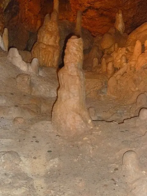 Cave formations rising from the rocky floor.