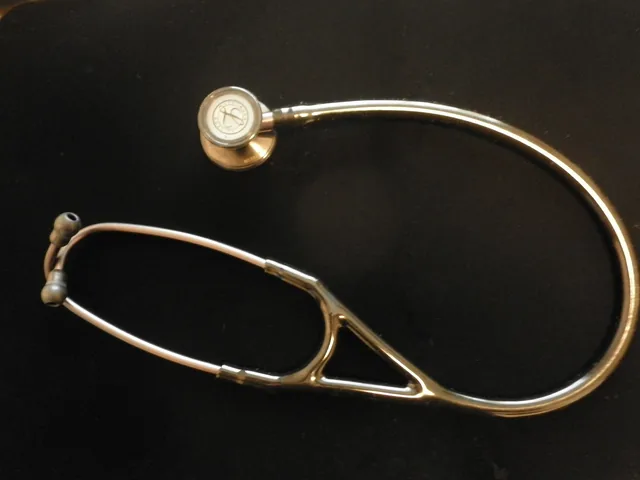 A stethoscope arranged on a dark surface.