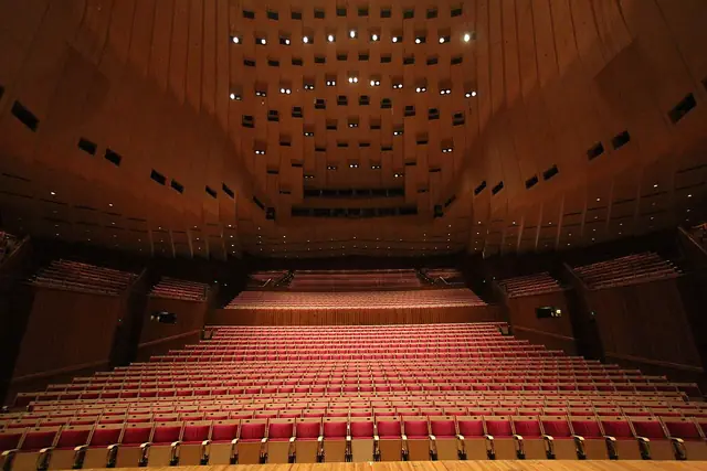 Rows of empty seats inside a wood-panelled concert hall.