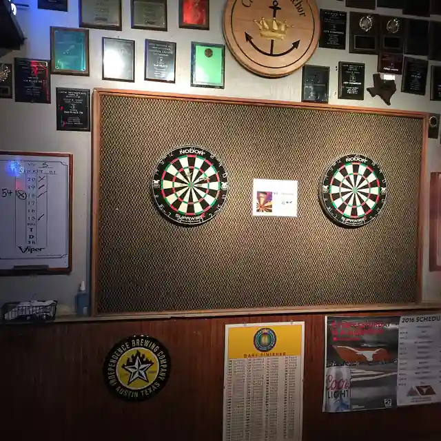 Two dartboards mounted side by side on a wall in a games area.