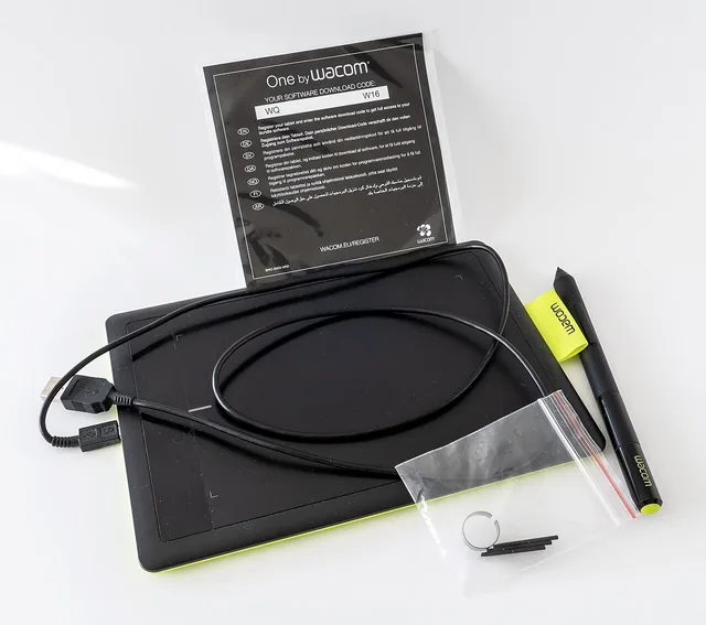A graphics tablet with its drawing pen and accessories.