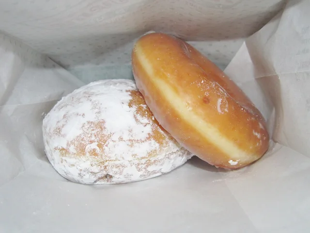 Doughnuts with glazed and powdered-sugar coatings.