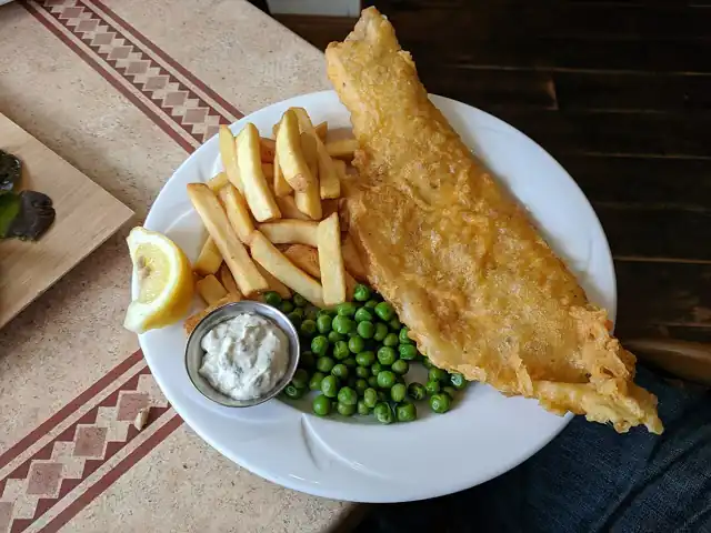 Battered fish with chips and a lemon wedge.
