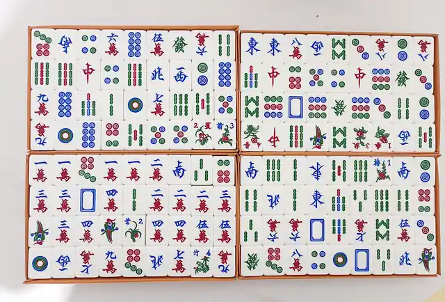 A set of traditional mahjong tiles arranged in open trays.