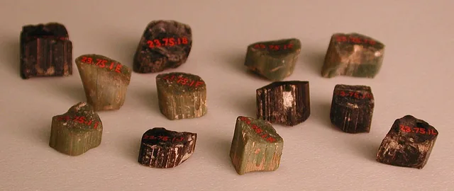 Small glass mosaic tesserae from a historic collection, arranged on a plain surface.