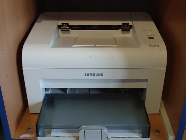 A light-coloured desktop laser printer.