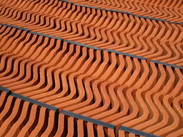 Rows of terracotta roof tiles packed together for storage or transport.