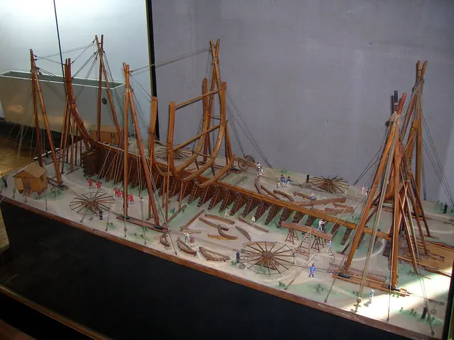 A detailed scale model showing a wooden sailing ship under construction.