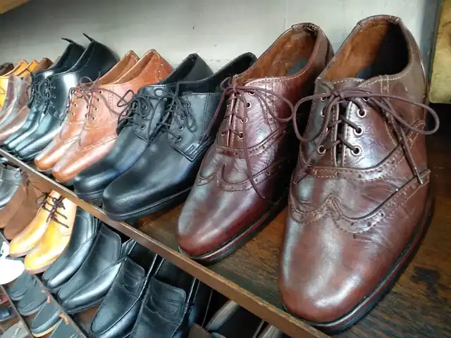 Brown and black leather dress shoes displayed on a rack.