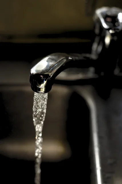 Water running from a metal tap.