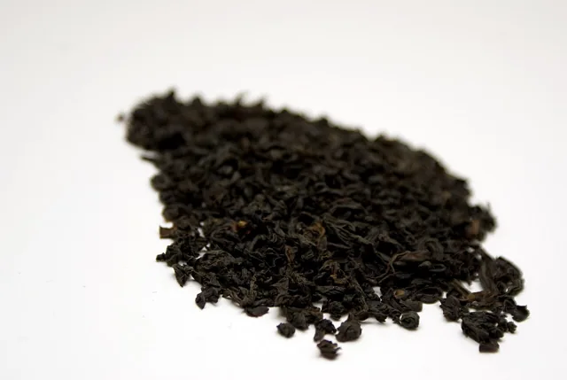 A small pile of loose black tea leaves.