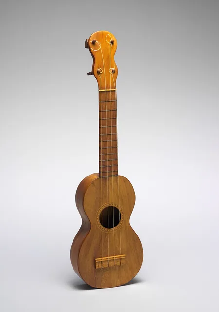 A wooden ukulele photographed against a plain background.