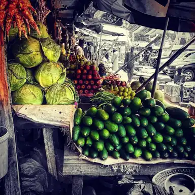 Cabbages and other fresh produce displayed at a market stall.