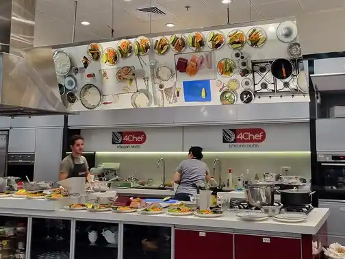 A chef preparing sushi in a cooking-school kitchen.