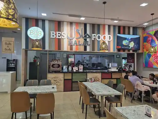 Tables in front of a halal-food restaurant counter.