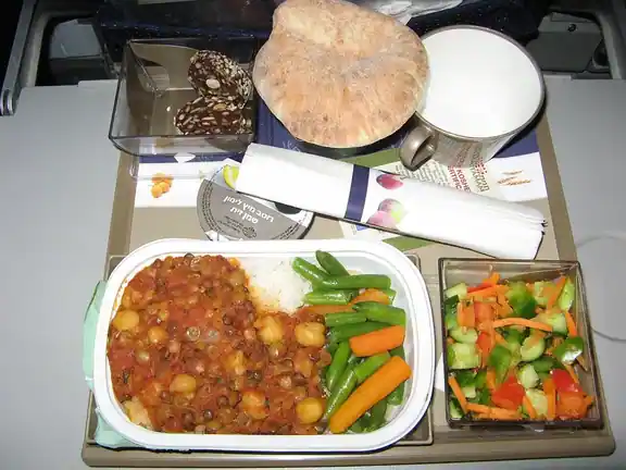 A vegan meal with vegetables, rice and bread.