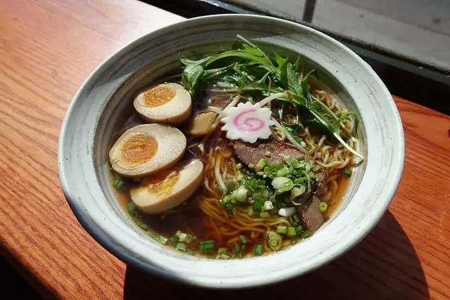 A bowl of ramen with noodles and toppings.