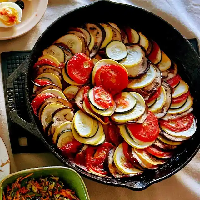 Sliced vegetables arranged in a pan of homemade ratatouille.